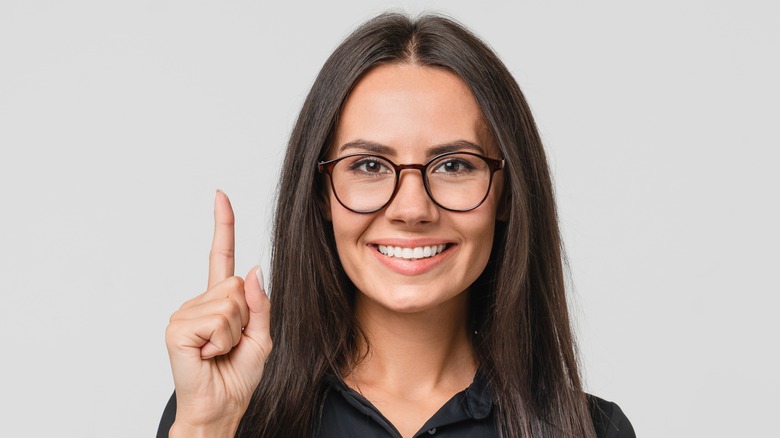 Smiling woman holding up finger