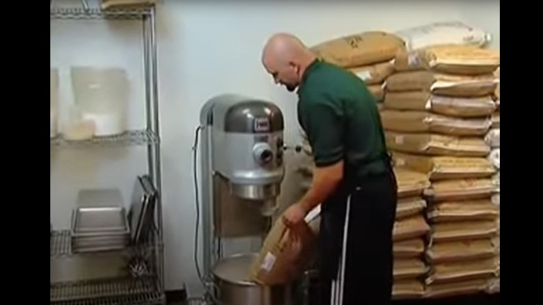 Staff member making pizza dough