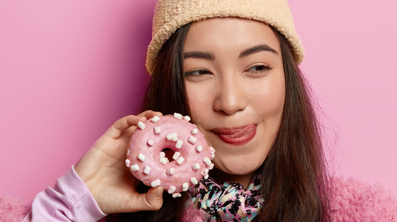 Teenage girl holding pink doughnut