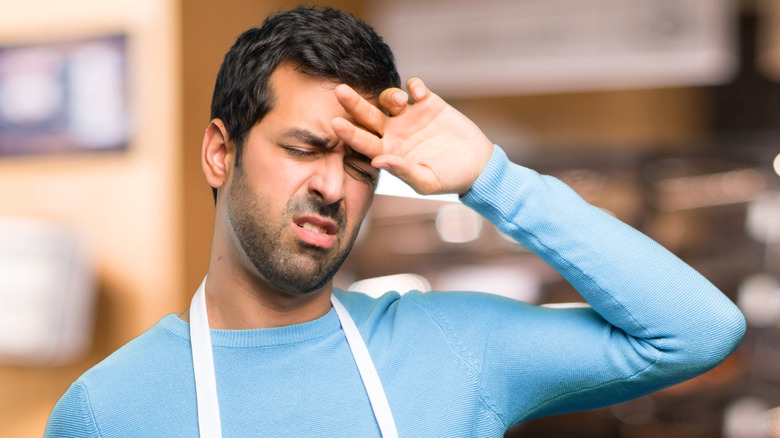 Exhausted server wiping brow