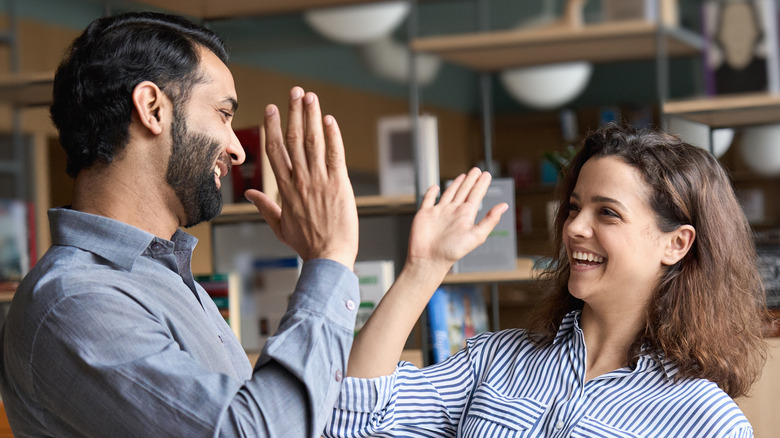 Smiling coworkers high fiving