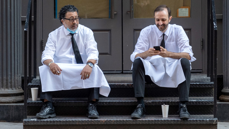 two waiters sitting on stoop