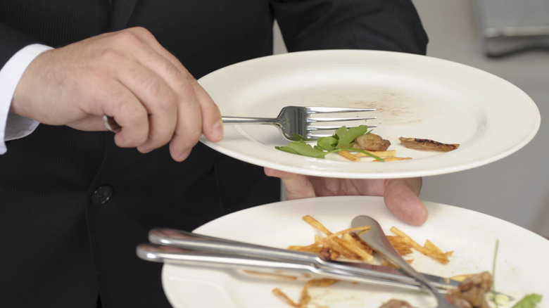 waiter clearing two plates