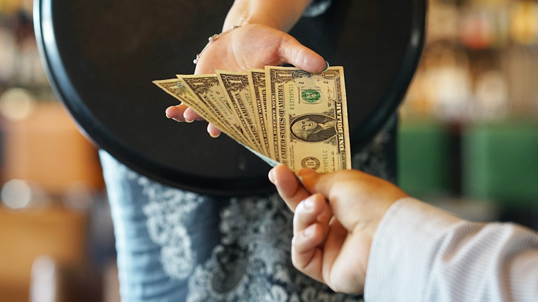 waitress receiving cash from man