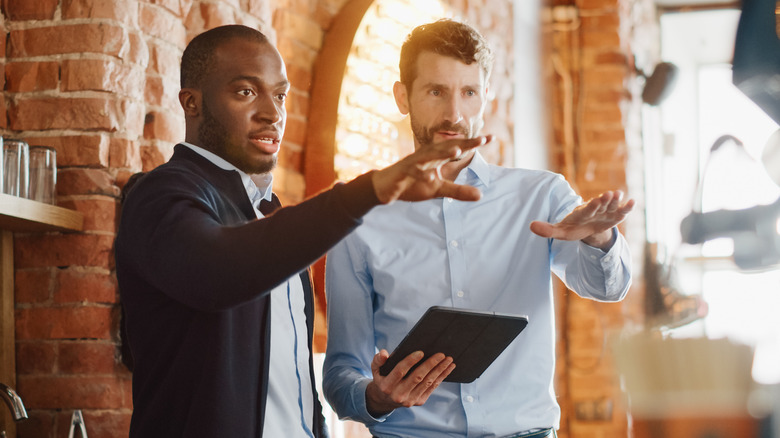 two focused men with tablet