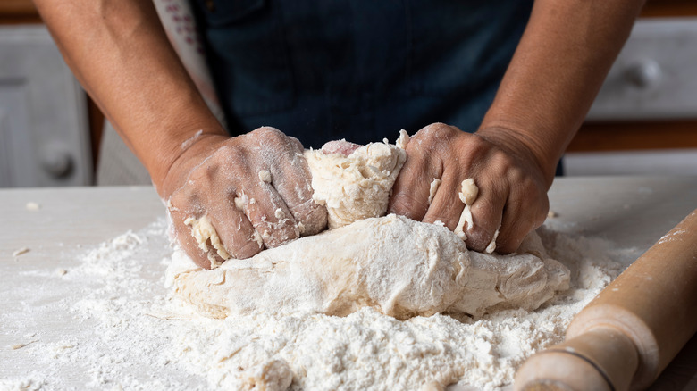 person making pizza dough