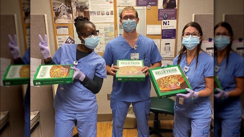 nurses holding Marco's Pizza boxes