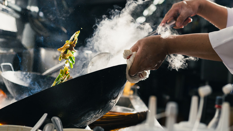 tossing vegetables in hot wok