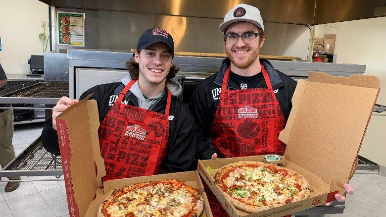 Papa John's employees holding pizzas