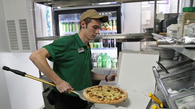 Papa John's employee boxing a pizza