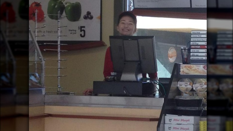 An employee smiling behind the counter.