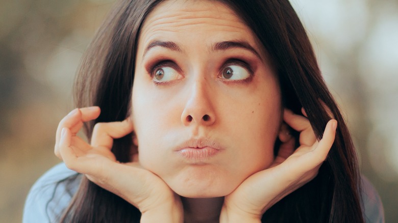 Woman plugging ears with fingers