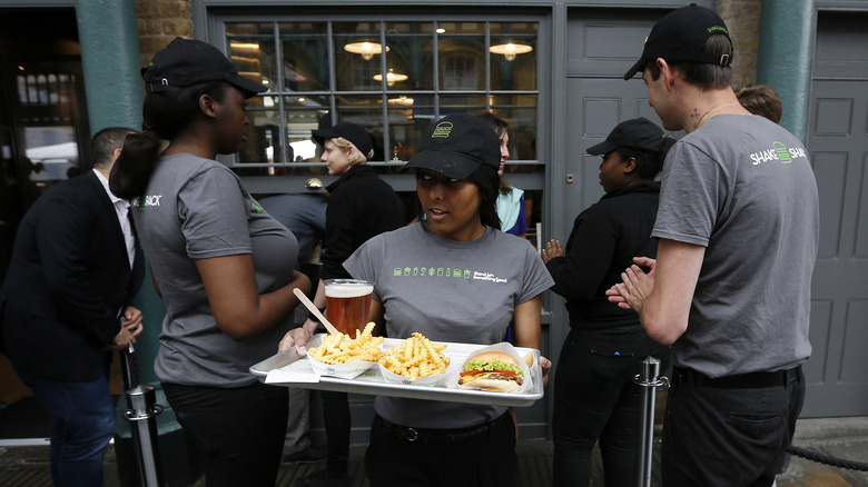 An employee carries a tray of food to customers.