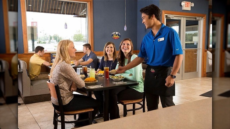 Restaurant employee smiling at customers