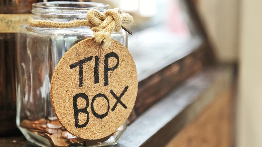 Glass tip jar on wooden counter