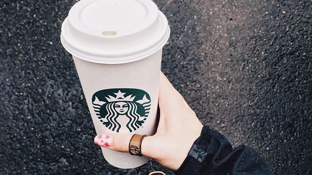 Hand holding Starbucks cup