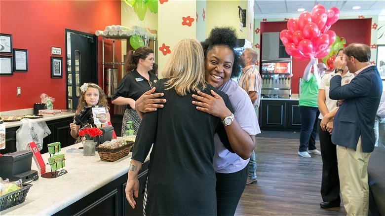 Two people hugging restaurant backdrop