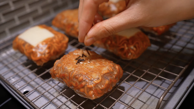 Person seasoning ramen wrapped in rice paper