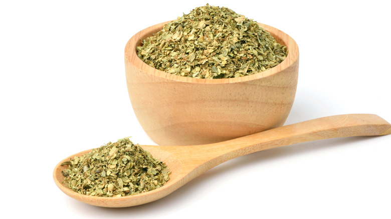 Dried oregano in wooden bowl and spoon