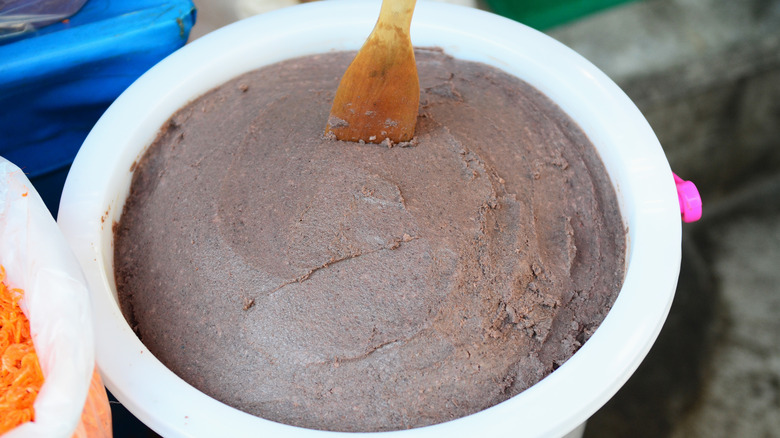 Thick anchovy paste in white bowl with wooden spoon