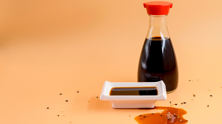 Soy Sauce bottle with dish of soy sauce slightly spilled