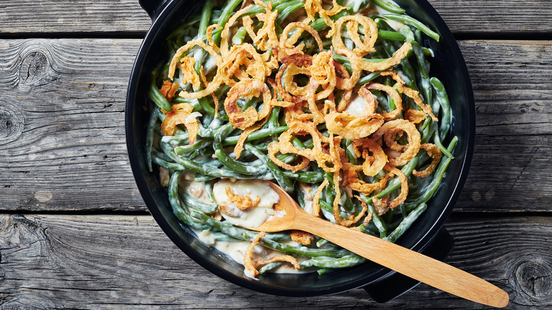 Green beans, creamy sauce, and fried onions in pan