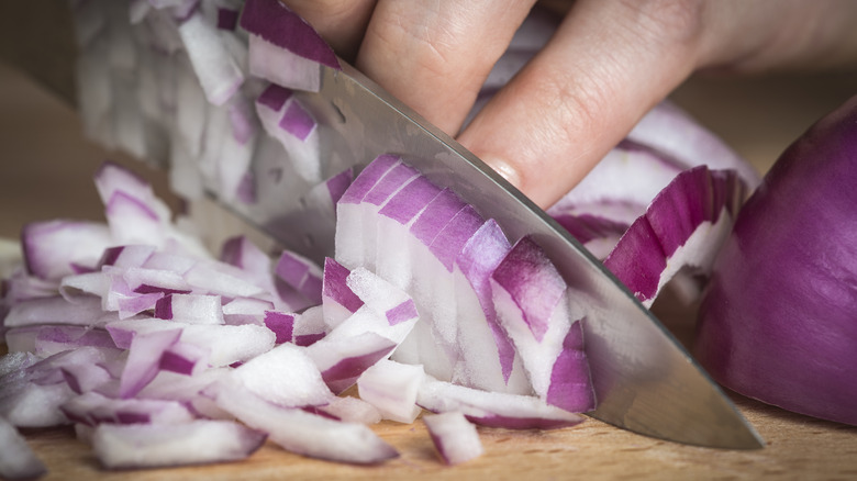 hand chopping red onions with knife