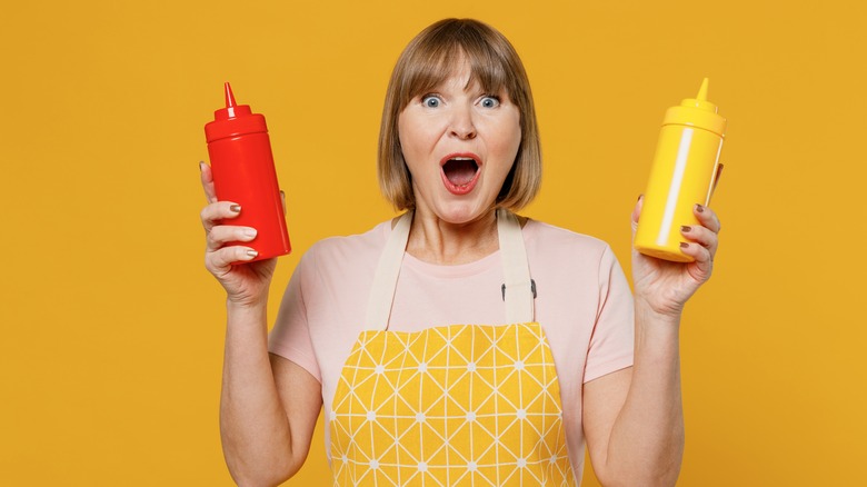 Woman hold ketchup and mustard bottles