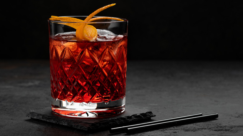 tumbler of negroni on a black background