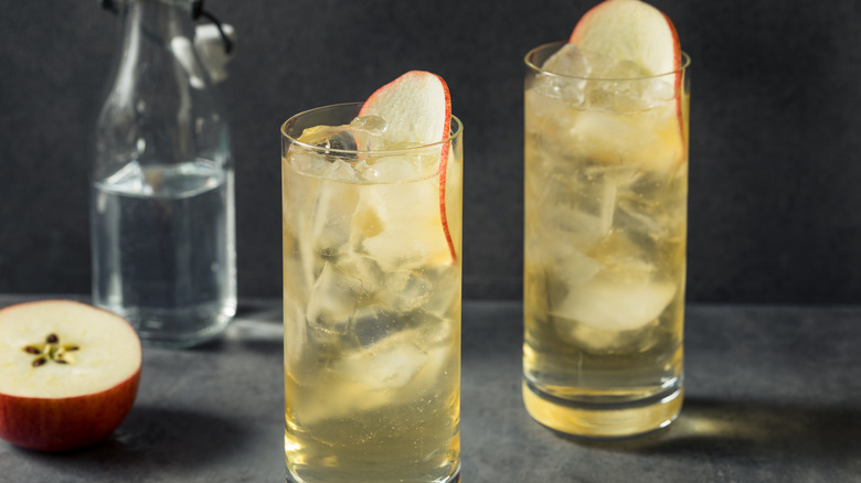 Two cocktails garnished with apple slices 
