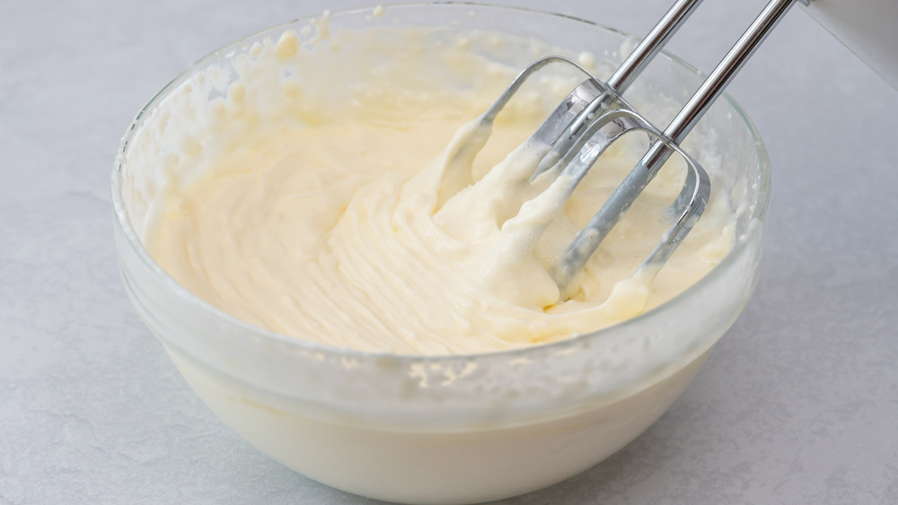 Cream cheese frosting in bowl with beaters