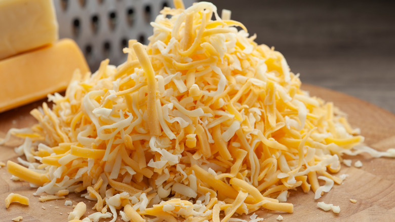 Close up of shredded cheese on a wooden block