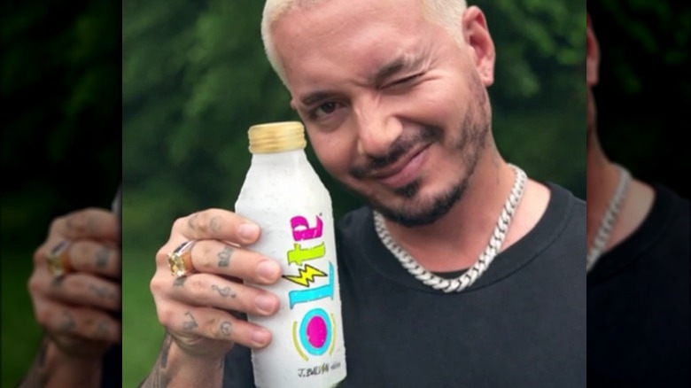 J Balvin holding up his self-designed miller lite pint