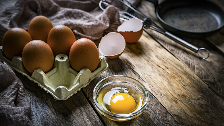 eggs in carton with cracked egg