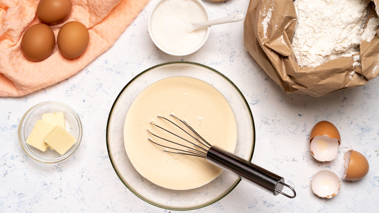 ingredients to make pancakes including flour, salt, milk, and eggs