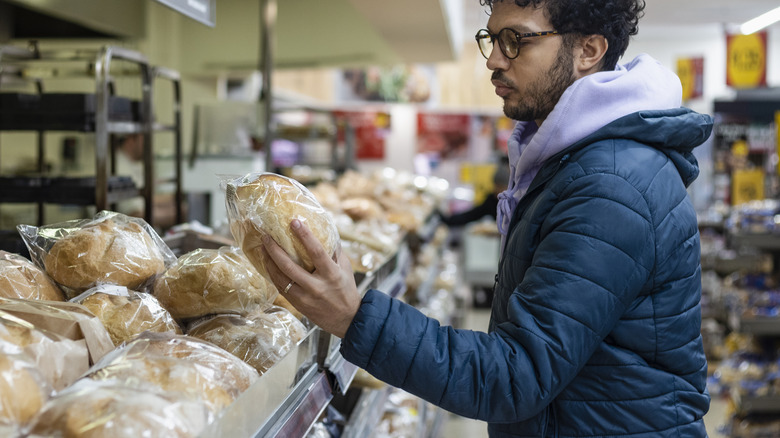 man looking at bread loaf