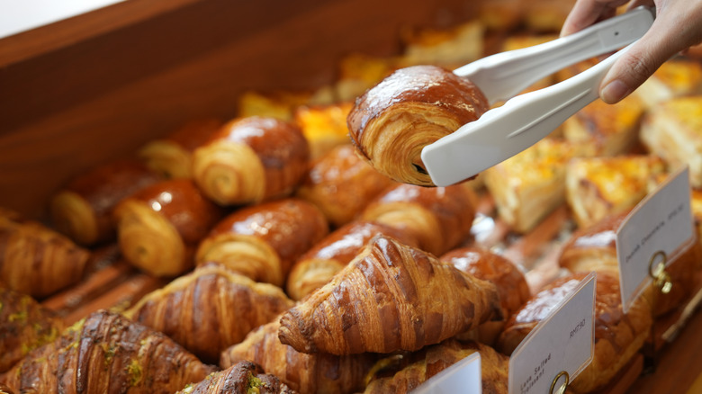 hand holding tongs with pastry