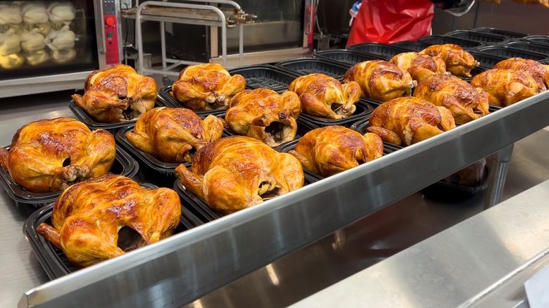 employee preparing rotisserie chicken