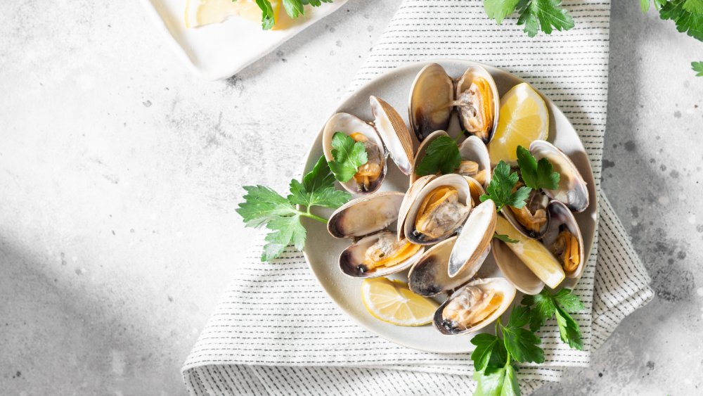 cooked clams on plate with lemon wedge