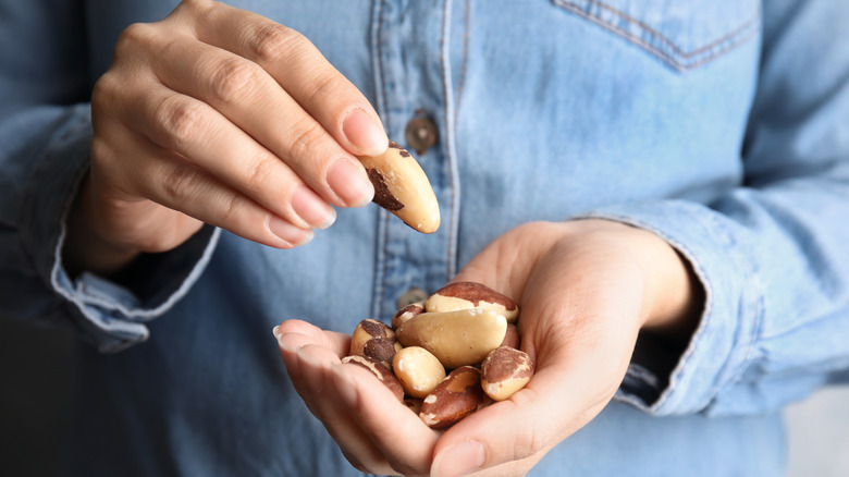 Person snacking on handful of Brazil nuts