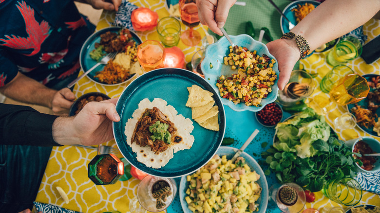 people sharing a table full of Tex-Mex food