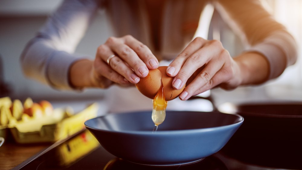 Woman cracking an egg