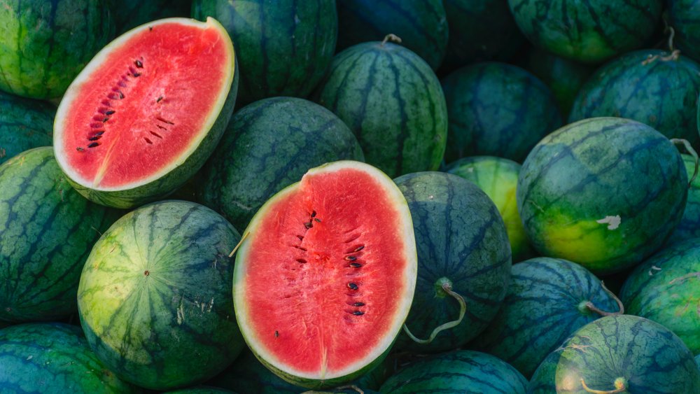 pile of watermelons with two ripe melon halves