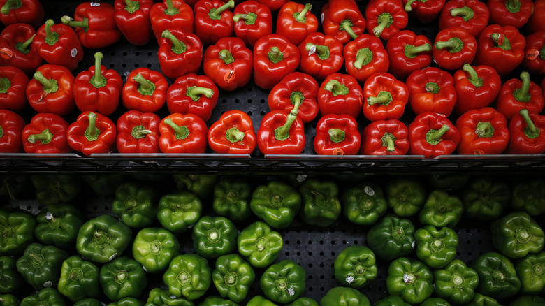 Red and green bell peppers on shelves