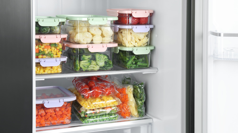 Food in covered containers and plastic bags in a refrigerator