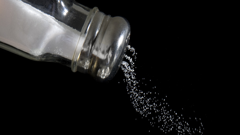 Salt shaker with grains of salt pouring out