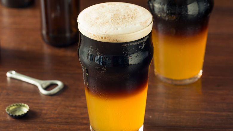 Black and tan beer in glass on wood table