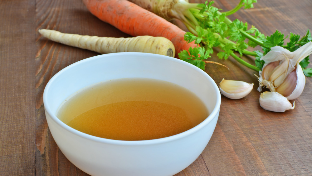 broth in bowl with veggies in background