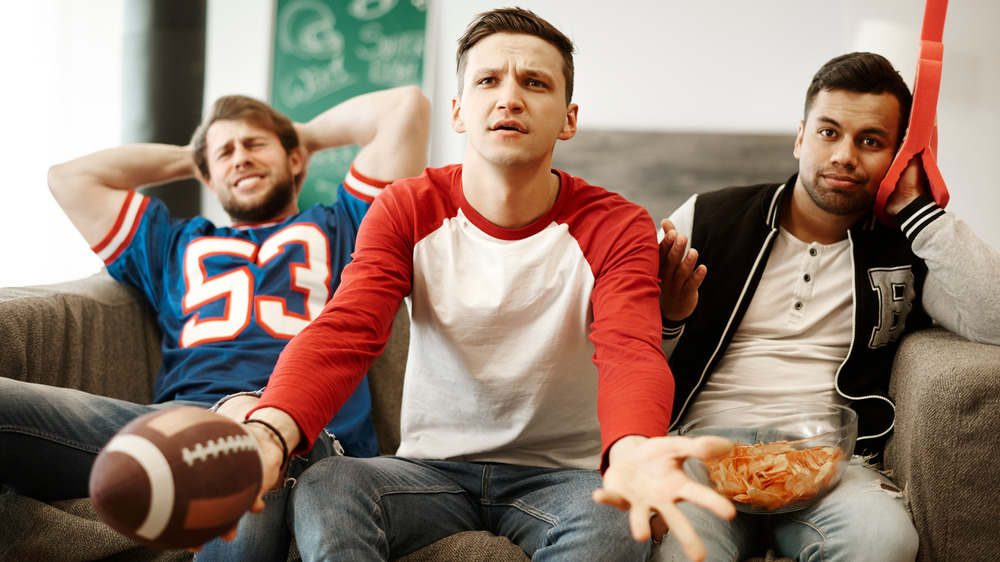 Disappointed football fans watching TV