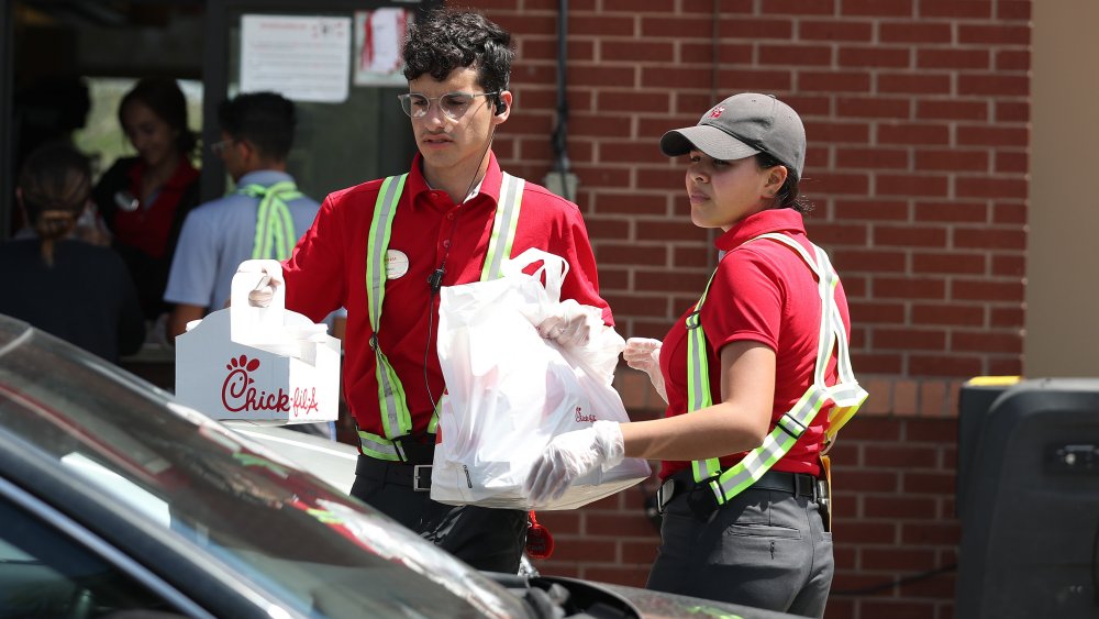 Chick-fil-A workers delivering a curbside pick-up order 